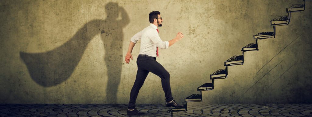 Featured image for article titled "How Digital Transformation is Driving Customer Experience" showing a man walking up the stairs with a shadow shaped like a superhero with a cape behind him.